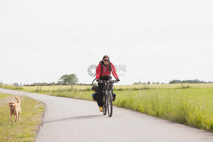 男子与狗一起骑自行车图片