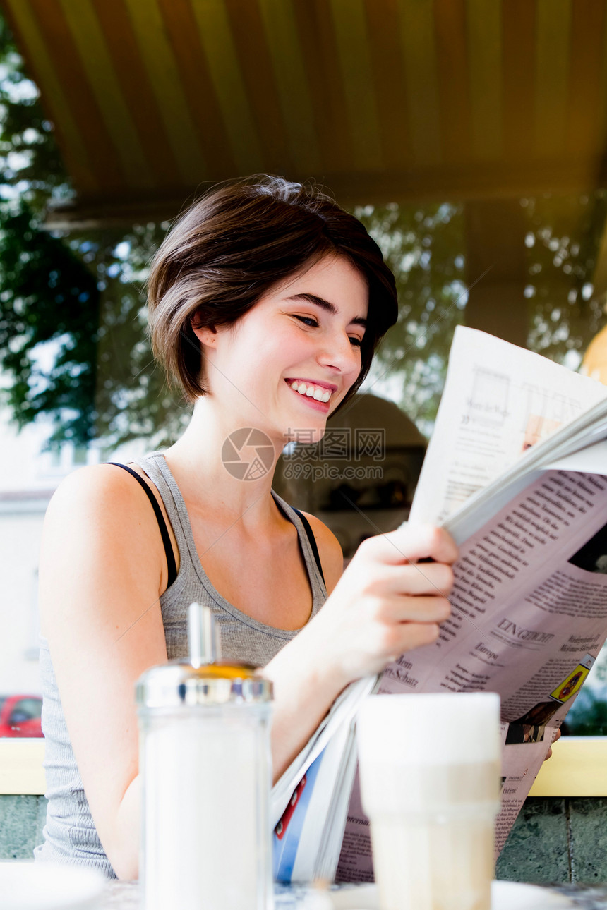 妇女在咖啡馆阅读报纸图片