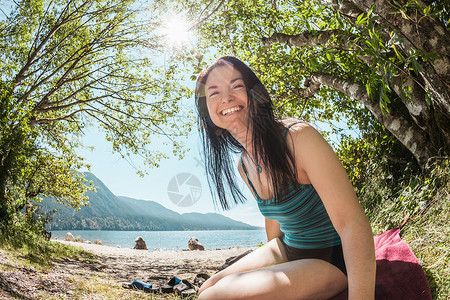 坐在农村湖边的微笑妇女图片
