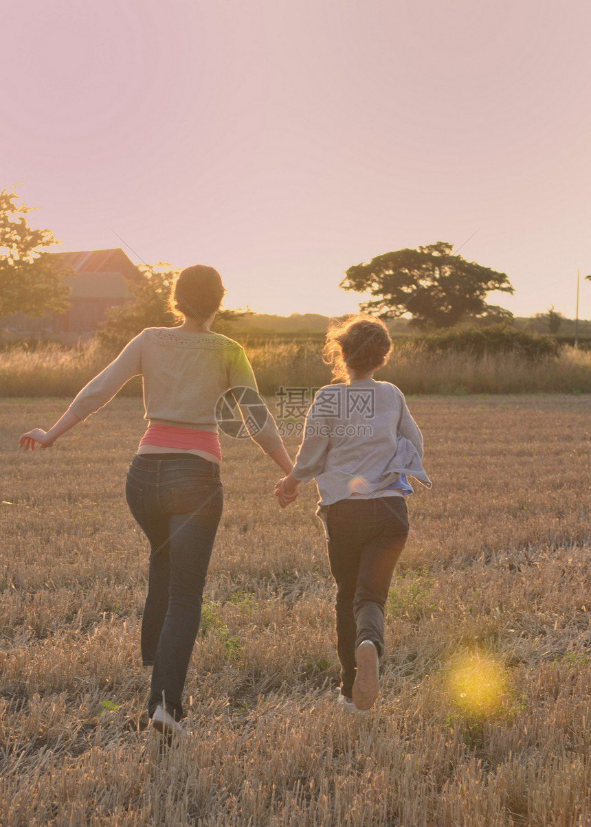 母亲和女儿在田野中奔跑图片