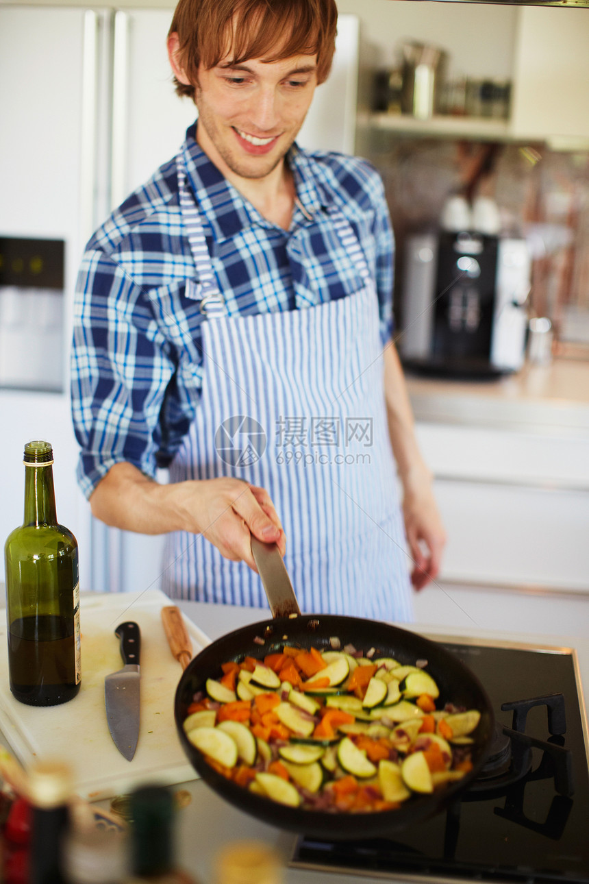 在厨房煎蔬菜的男士图片