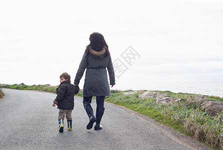 母亲和儿子在农村公路上行走图片