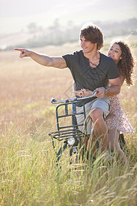 在草地上骑车的情侣图片