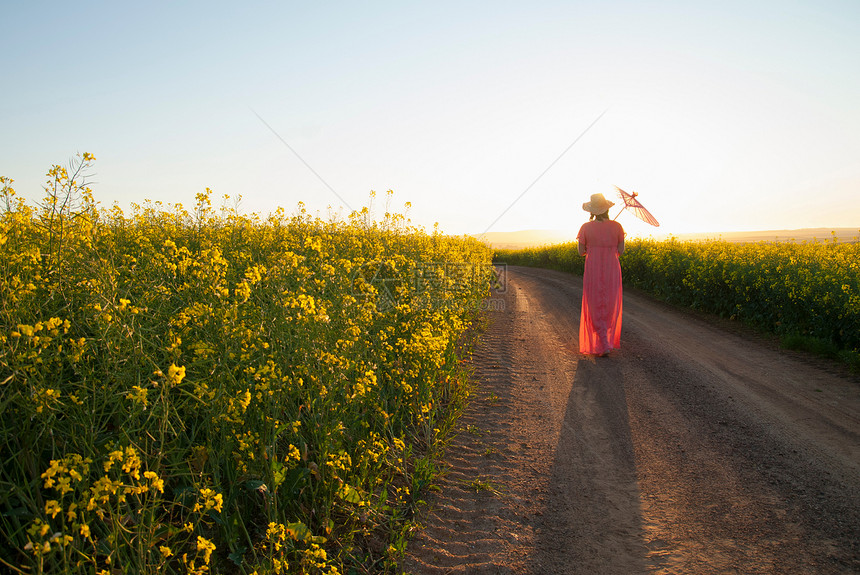 女性行走在乡间道路上图片