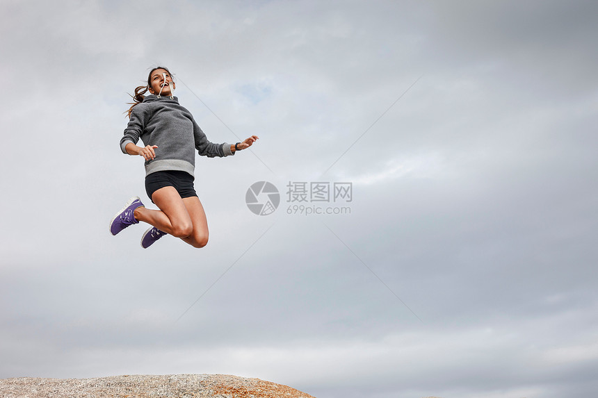 女人在巨石上跳跃图片