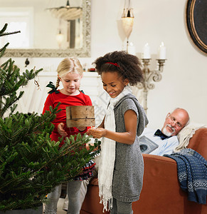 小女孩在装饰圣诞树背景图片