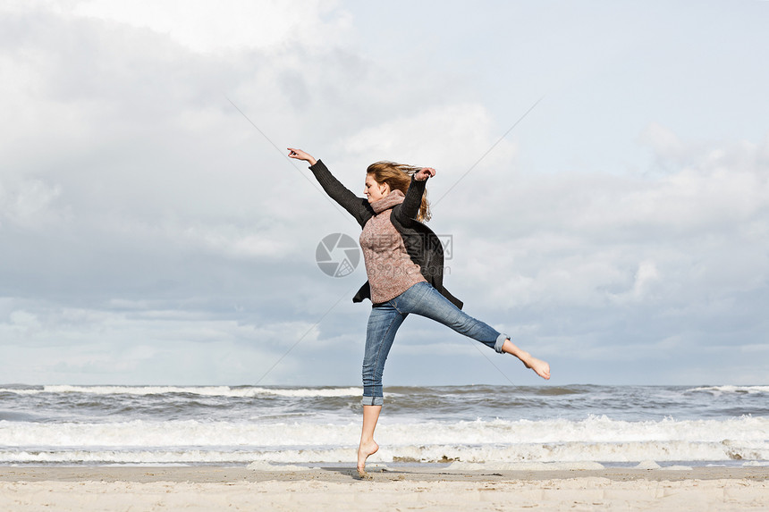 在海滩上跳跃的妇女图片