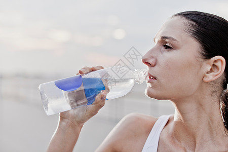 户外饮水的运动女性图片