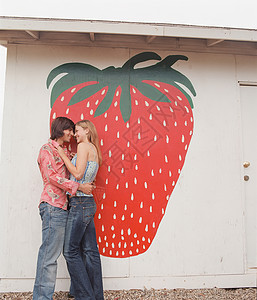 草莓壁画前拥抱的情侣图片