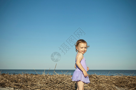 女孩站在干稻草旁图片