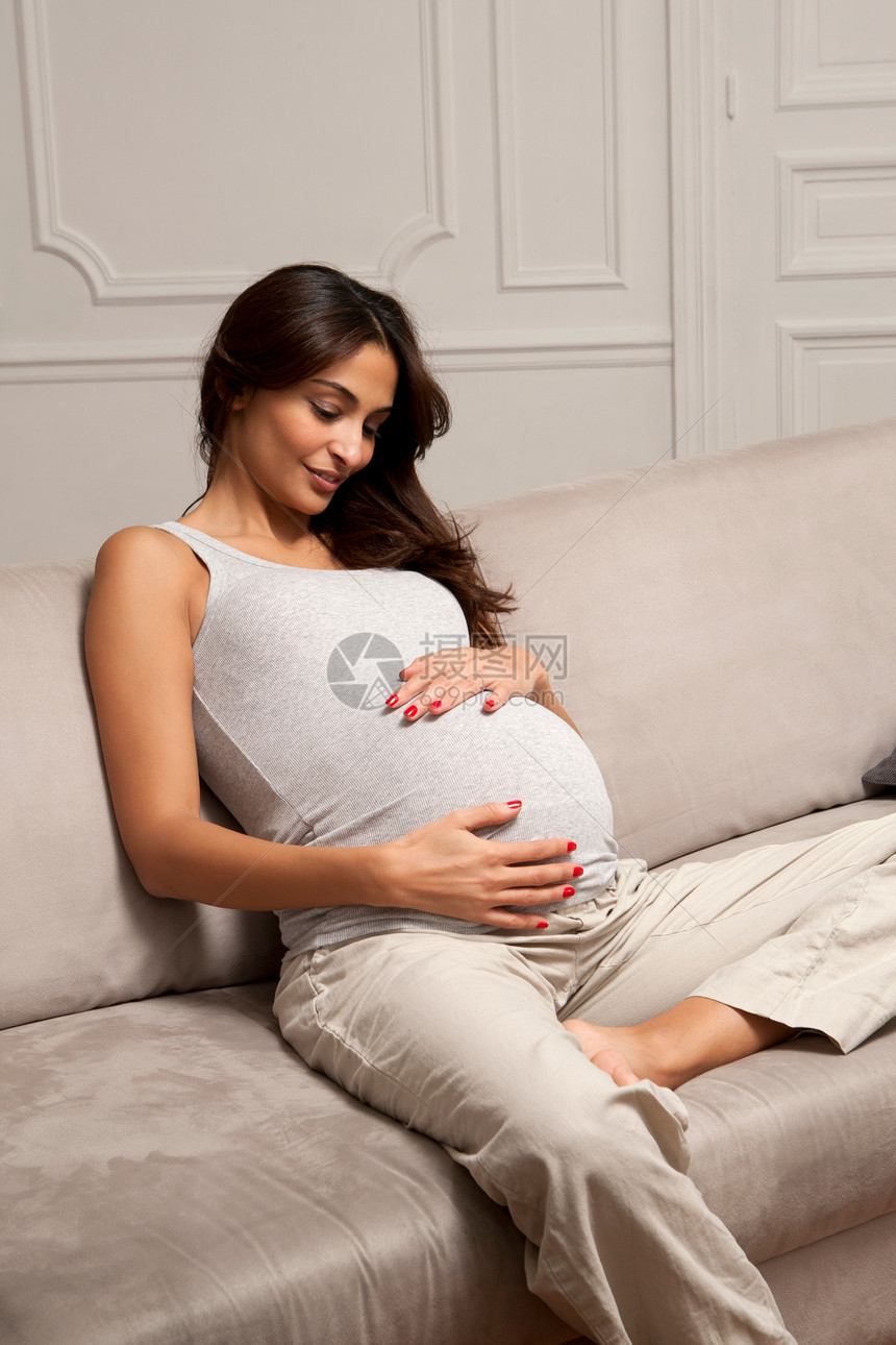 在沙发上抚摸肚子的孕妇图片