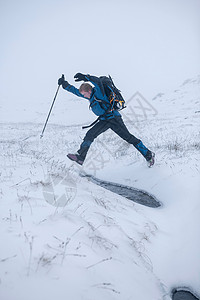 在雪地上跳跃的登山者图片