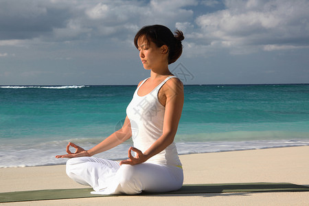 热带海滩上的美女锻炼瑜伽冥想图片