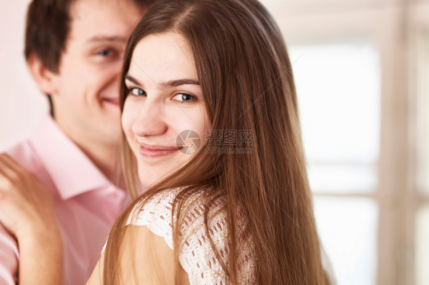 微笑的情侣拥抱在室内图片
