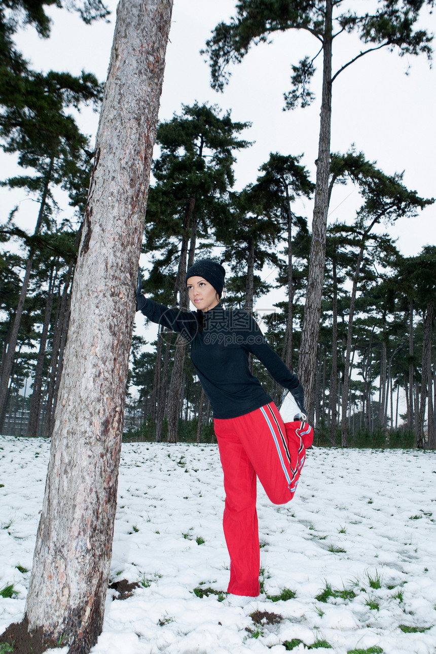 在雪林中伸展的女性图片