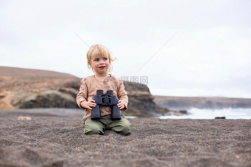 在海滩上使用望远镜的女孩图片