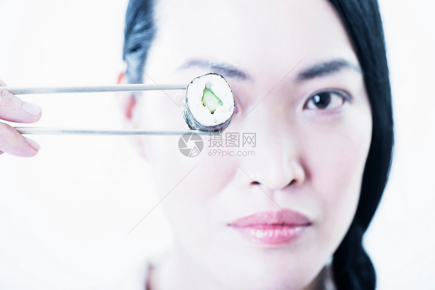 女人对着眼睛拿寿司图片