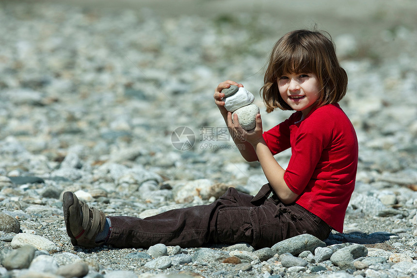 女孩在海滩上玩石头游戏图片