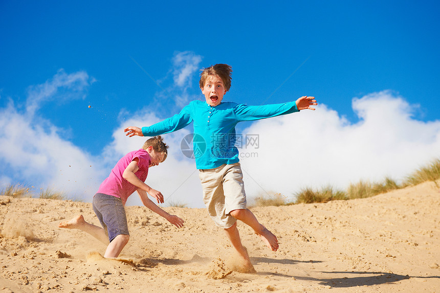 两个男孩在沙丘下玩耍打闹图片