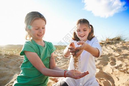 两个女孩笑着玩沙图片
