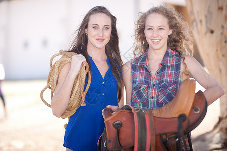 携带马鞍和绳索的年轻妇女图片