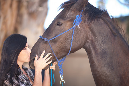 年轻女人亲吻马的鼻子图片