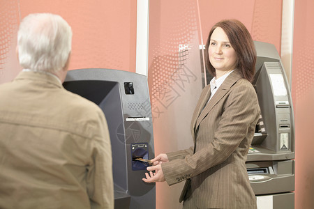 使用自动取款机取钱的妇女背景图片