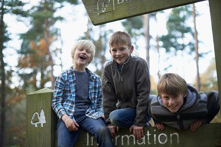三个男孩在森林里攀登图片