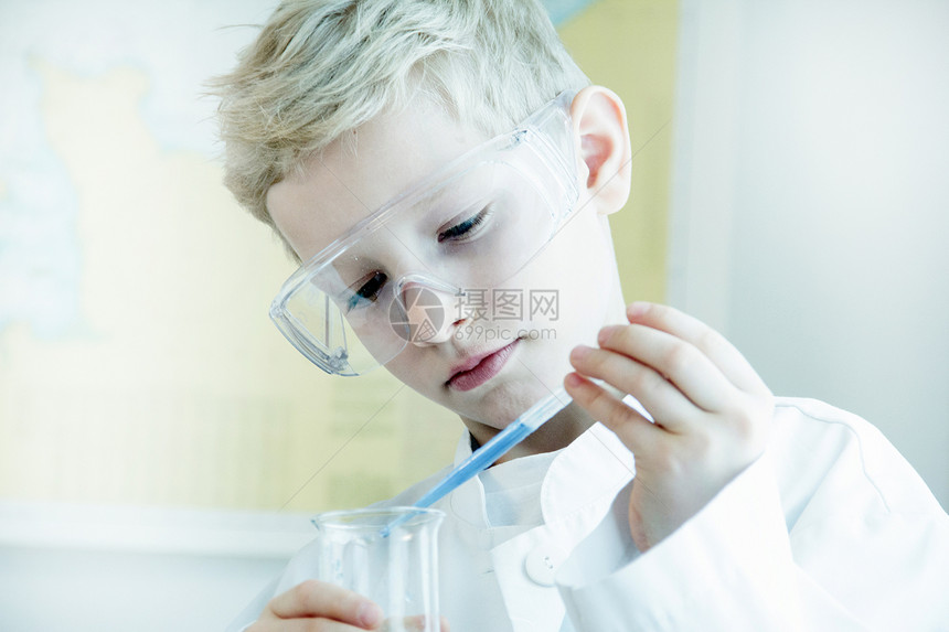 身戴安全护目镜进行科学实验的男孩图片