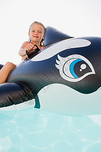鲸鱼上女孩女孩在充气鲸鱼上玩耍背景
