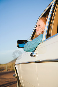 一位年轻女士从车窗往外看背景图片