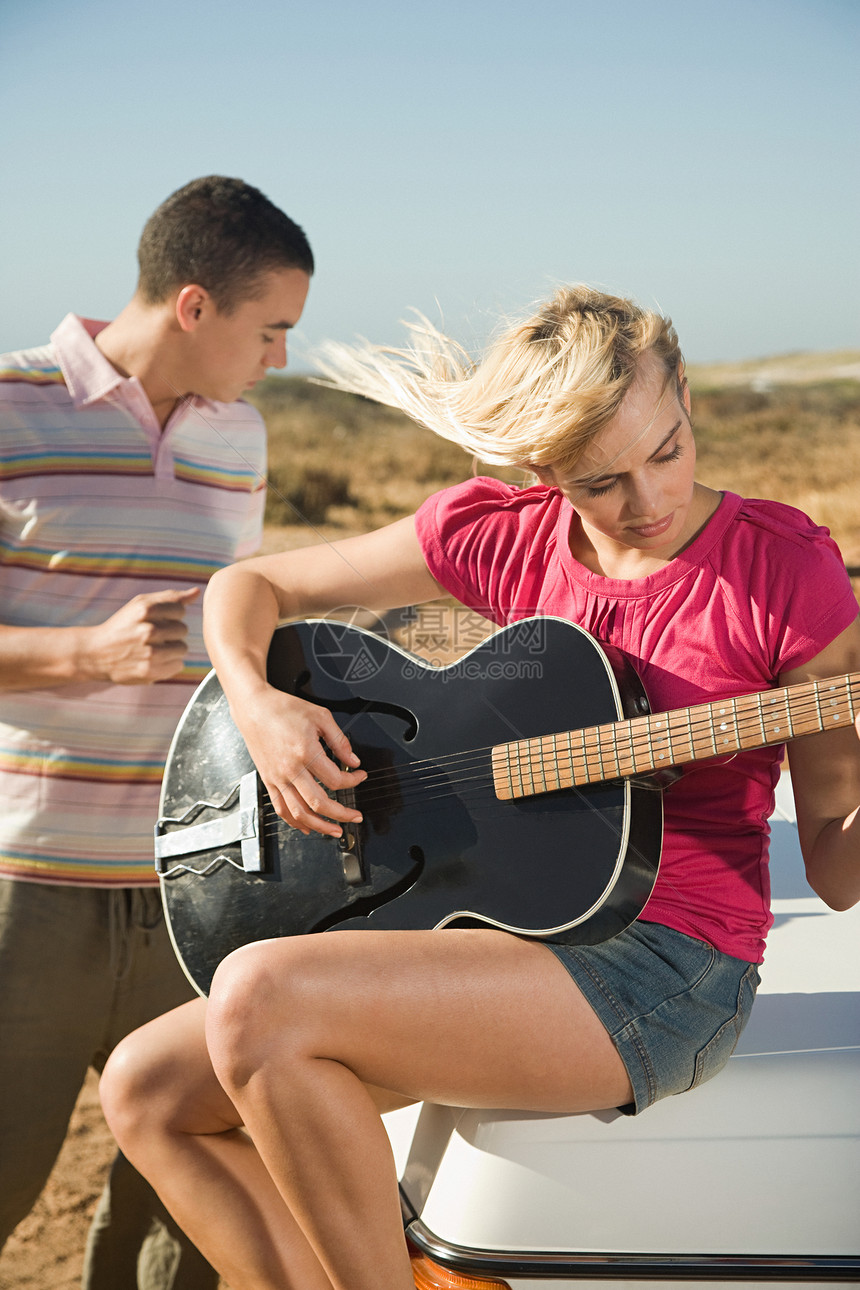 年轻夫妇在户外弹吉他图片