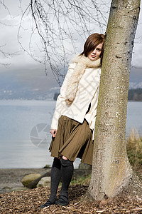 年轻女人靠着树上图片