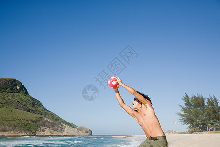 在海边打橄榄球的男孩图片