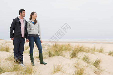 在沙滩上站着的情侣图片