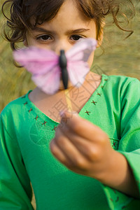 一个女孩拿着玩具蝴蝶背景图片