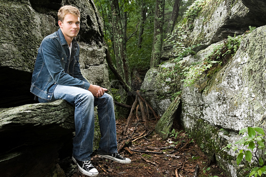 少年男孩坐在岩石上图片