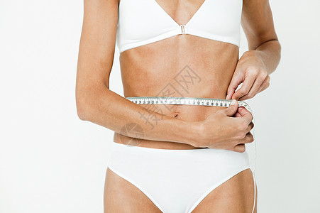 减肥的女人在测量腰围图片