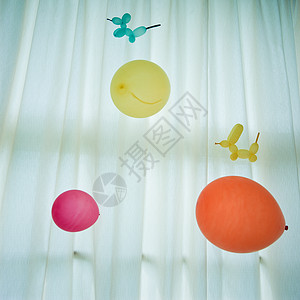 白色窗帘上的多彩气球图片