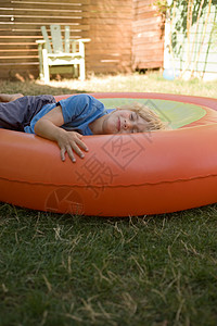 年轻男孩躺在充气球上图片