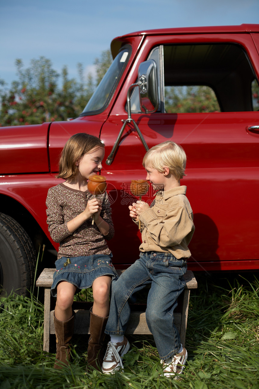 在卡车上吃着苹果的小孩图片