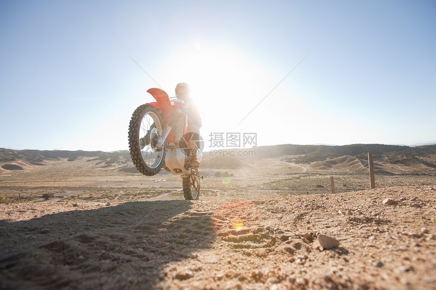 男人在泥土轨道上骑自行车图片