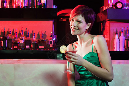 坐在鸡尾酒吧的快乐年轻女士背景图片
