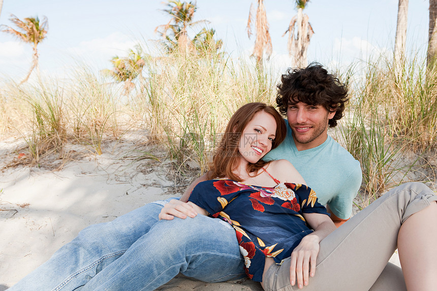 年轻夫妇躺在沙滩上肖像图片