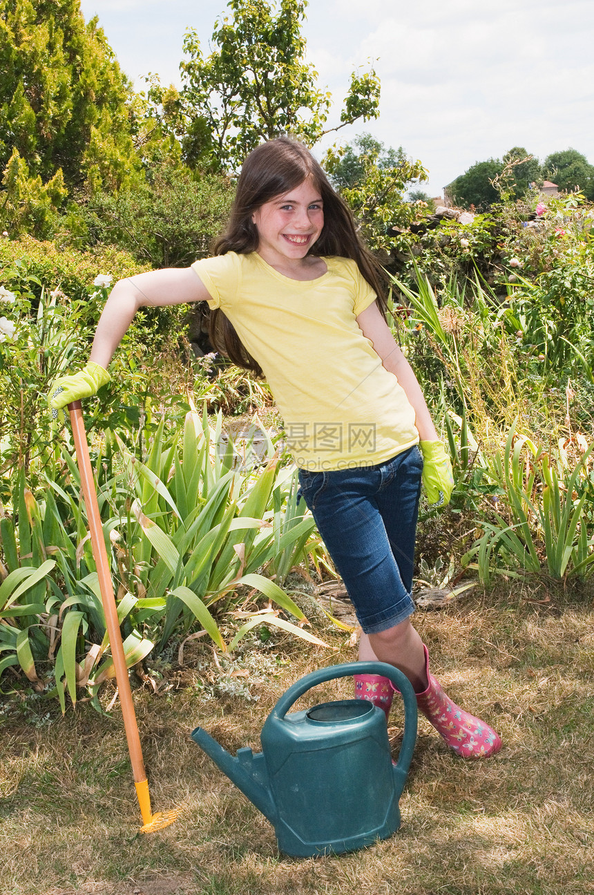 女孩在花园里带着子和水罐图片