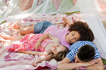 三个睡在夏织网帐篷里的孩子背景图片