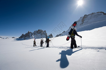 4名男子携带雪板图片