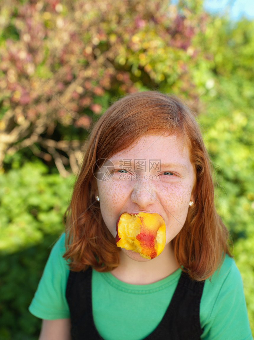 女孩把桃子放在嘴里图片