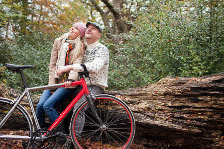 公园里扶着自行车坐着休息的夫妇图片