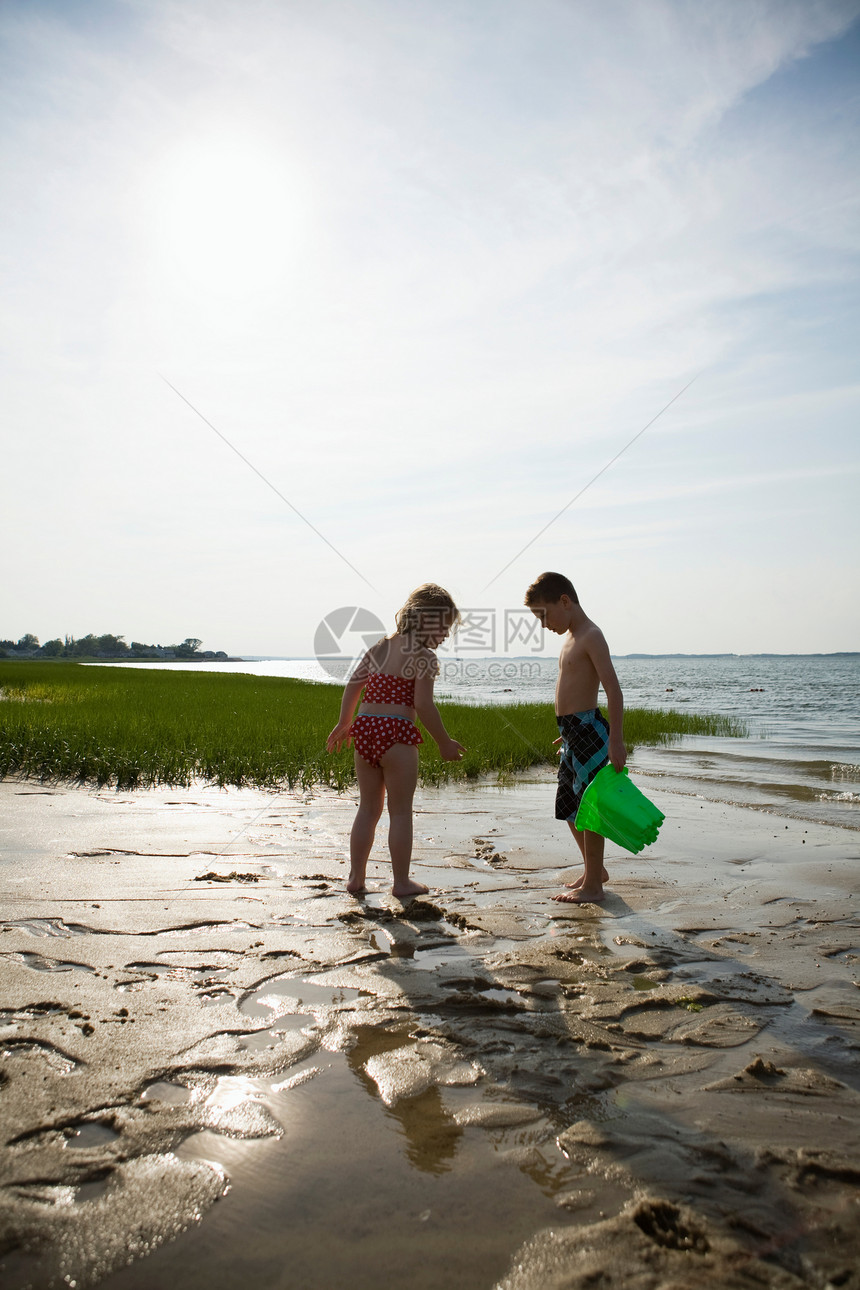 退潮时在海滩上玩耍的小孩图片